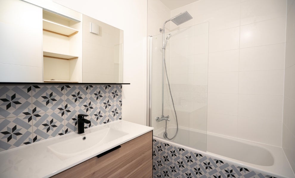 Salle de bain rénovée avec rangements et carrelages avec motifs